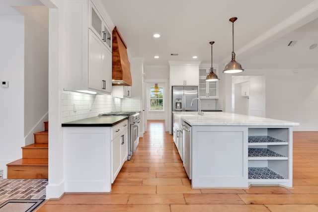 5926 Bit Pl, Baytown, TX 77523 - kitchen with appliances with stainless steel finishes, custom range hood, backsplash, white cabinets, and light wood-style floors