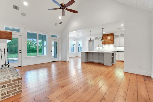 5926 Bit Pl, Baytown, TX 77523 - unfurnished living room with high vaulted ceiling, ceiling fan, a sink, light wood-style flooring, and recessed lighting