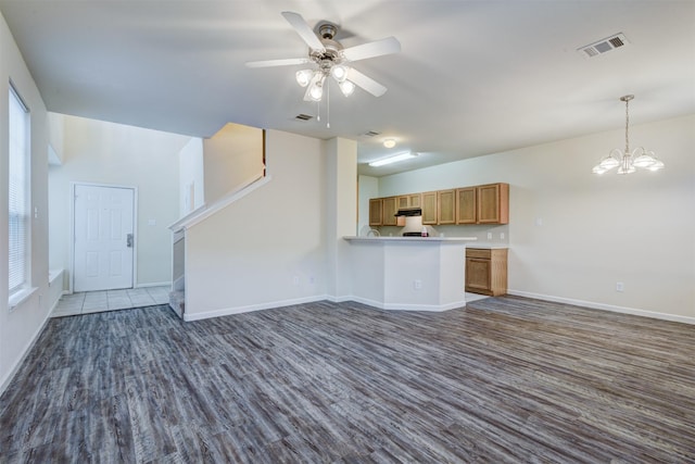 6106 Yorkglen Manor Ln, Houston, TX 77084 - unfurnished living room with dark wood-style floors, stairs, ceiling fan, and plenty of natural light