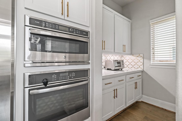 5318 Abington Creek Ln, Sugar Land, TX 77479 - kitchen featuring light countertops, decorative backsplash, dark wood-style floors, white cabinetry, and baseboards