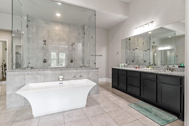 5318 Abington Creek Ln, Sugar Land, TX 77479 - bathroom with a soaking tub, double vanity, a shower stall, tile patterned flooring, and baseboards