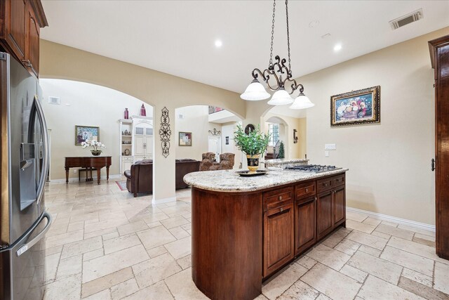 8917 Hawk Rd, Pearland, TX 77584 - kitchen featuring appliances with stainless steel finishes, stone tile flooring, arched walkways, recessed lighting, and hanging light fixtures