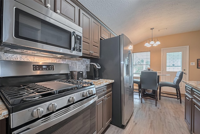 4559 Taino Dr, Baytown, TX 77521 - kitchen with appliances with stainless steel finishes, light wood-type flooring, tasteful backsplash, a chandelier, and lofted ceiling