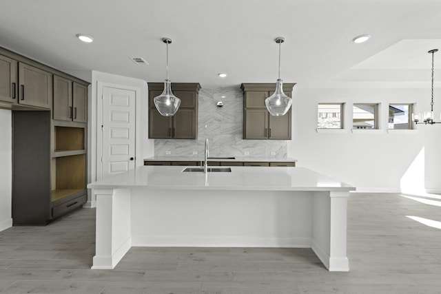 30415 Bermuda Hallow Bnd, Brookshire, TX 77423 - kitchen with a kitchen island with sink, light countertops, decorative backsplash, recessed lighting, and light wood-style flooring