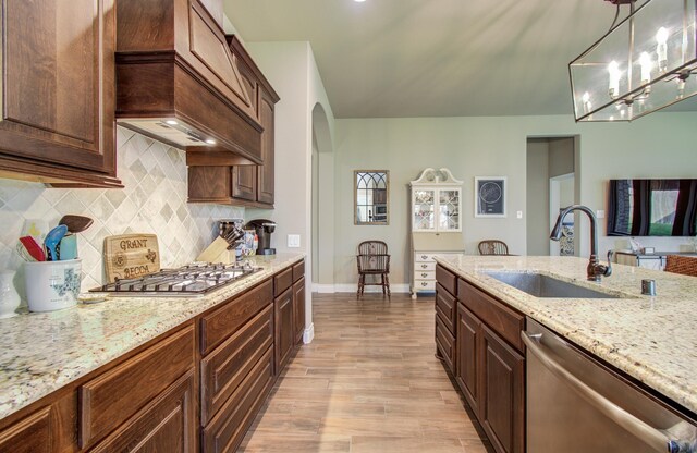 2335 Mayfield Trail Ct, League City, TX 77573 - kitchen with a sink, appliances with stainless steel finishes, light wood-style floors, arched walkways, and baseboards