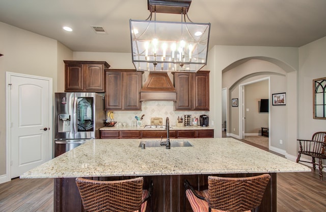 2335 Mayfield Trail Ct, League City, TX 77573 - kitchen featuring custom range hood, a sink, arched walkways, stainless steel fridge with ice dispenser, and backsplash