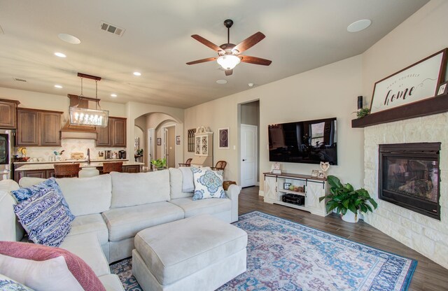 2335 Mayfield Trail Ct, League City, TX 77573 - living area featuring arched walkways, recessed lighting, a ceiling fan, dark wood finished floors, and a stone fireplace