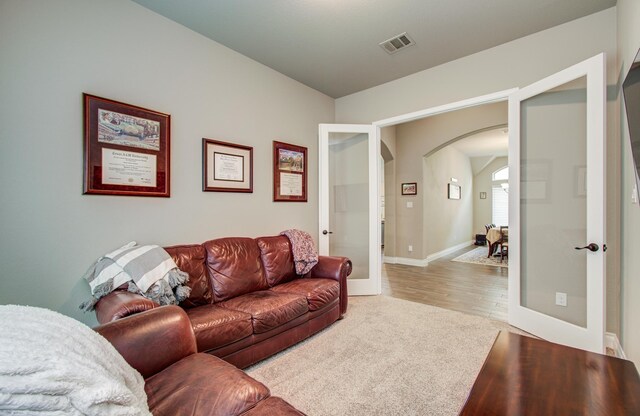 2335 Mayfield Trail Ct, League City, TX 77573 - living area with french doors, arched walkways, carpet floors, and baseboards