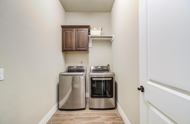 2335 Mayfield Trail Ct, League City, TX 77573 - laundry area with cabinet space, washing machine and dryer, baseboards, and wood finish floors