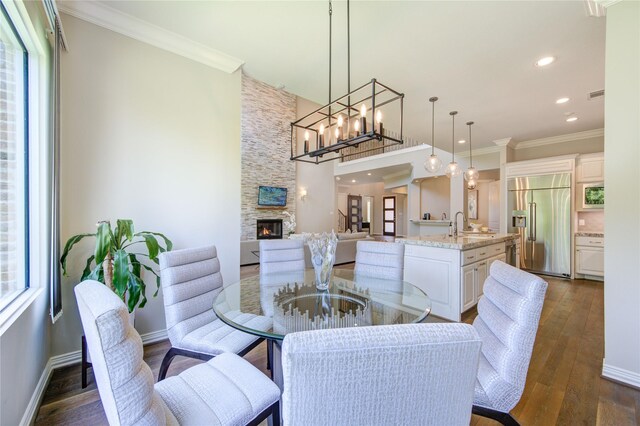13706 Northwood Meadow Cir, Houston, TX 77077 - dining area featuring a fireplace, dark wood-style floors, ornamental molding, baseboards, and recessed lighting