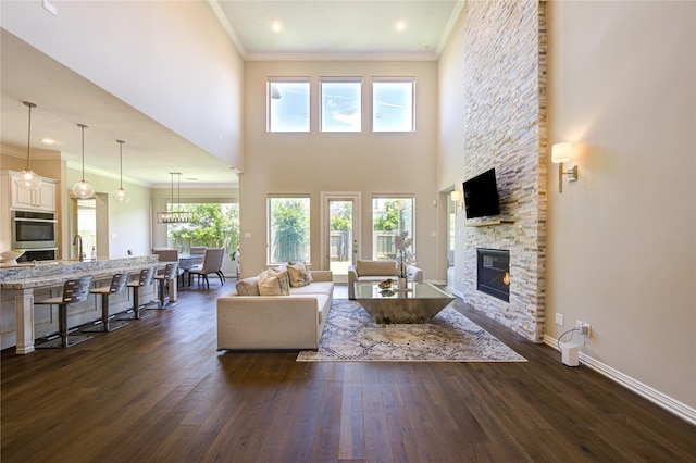 13706 Northwood Meadow Cir, Houston, TX 77077 - living area featuring a stone fireplace, dark wood-type flooring, ornamental molding, baseboards, and recessed lighting
