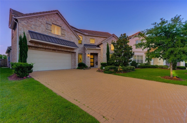 13706 Northwood Meadow Cir, Houston, TX 77077 - view of front facade with decorative driveway, a front yard, brick siding, an attached garage, and a standing seam roof