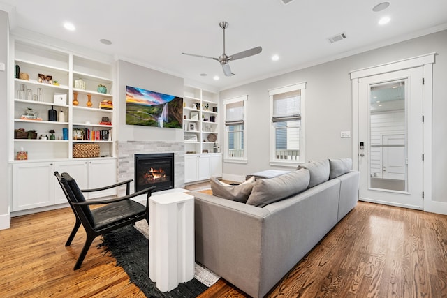 728 Allston St, Houston, TX 77007 - living room with a ceiling fan, light wood-style flooring, crown molding, a tile fireplace, and recessed lighting