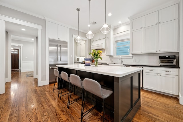 728 Allston St, Houston, TX 77007 - kitchen with stainless steel built in refrigerator, tasteful backsplash, a breakfast bar area, a center island, and ornamental molding