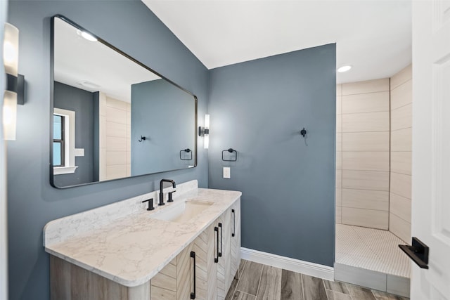 12986 Wood Harbour Dr, Montgomery, TX 77356 - bathroom with vanity, a tile shower, baseboards, wood finished floors, and recessed lighting