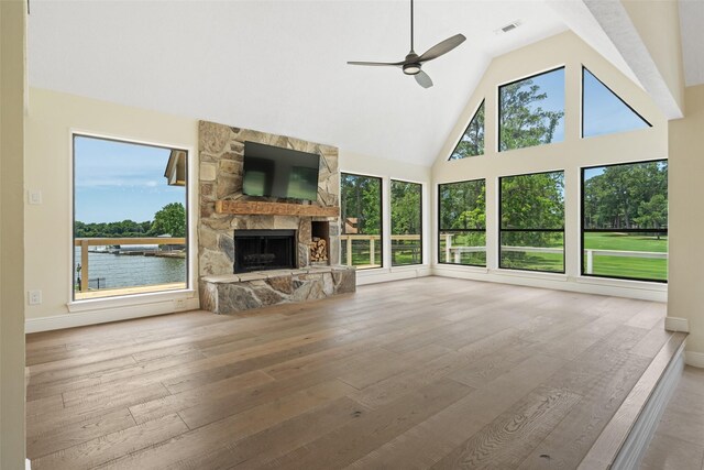 12986 Wood Harbour Dr, Montgomery, TX 77356 - unfurnished living room with a ceiling fan, high vaulted ceiling, wood-type flooring, a stone fireplace, and baseboards