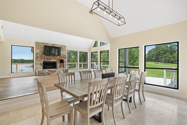 12986 Wood Harbour Dr, Montgomery, TX 77356 - dining space with healthy amount of natural light, a fireplace, baseboards, high vaulted ceiling, and light tile patterned floors