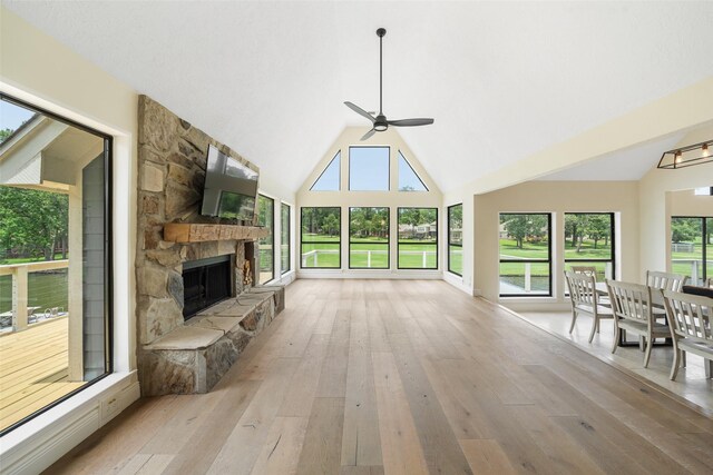 12986 Wood Harbour Dr, Montgomery, TX 77356 - unfurnished living room featuring a ceiling fan, light wood-type flooring, high vaulted ceiling, and a fireplace