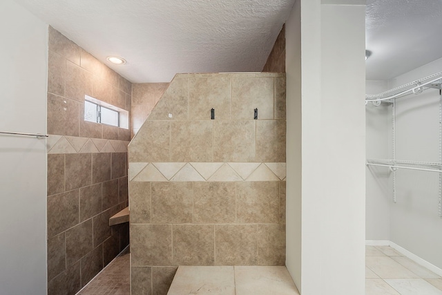 19523 Enchanted Grove Dr, Spring, TX 77388 - full bath featuring a walk in shower, tile patterned floors, a spacious closet, and a textured ceiling