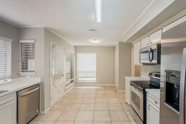19523 Enchanted Grove Dr, Spring, TX 77388 - kitchen with appliances with stainless steel finishes, a textured ceiling, light countertops, white cabinets, and light tile patterned floors