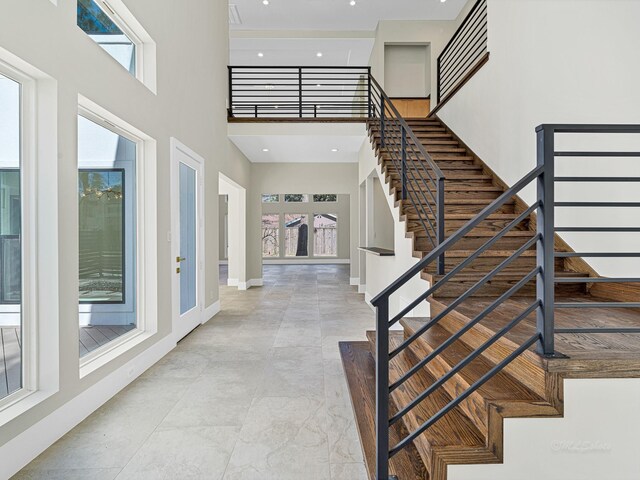 12914 Figaro Dr, Houston, TX 77024 - stairway featuring a towering ceiling, healthy amount of natural light, and baseboards