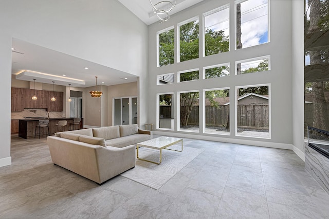 12914 Figaro Dr, Houston, TX 77024 - living room with a towering ceiling, a chandelier, baseboards, and recessed lighting