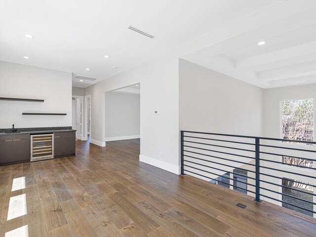12914 Figaro Dr, Houston, TX 77024 - unfurnished living room with wine cooler, recessed lighting, bar with sink, wood finished floors, and baseboards