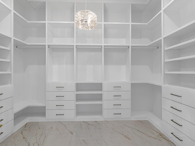12914 Figaro Dr, Houston, TX 77024 - spacious closet featuring light marble finish floors and a chandelier