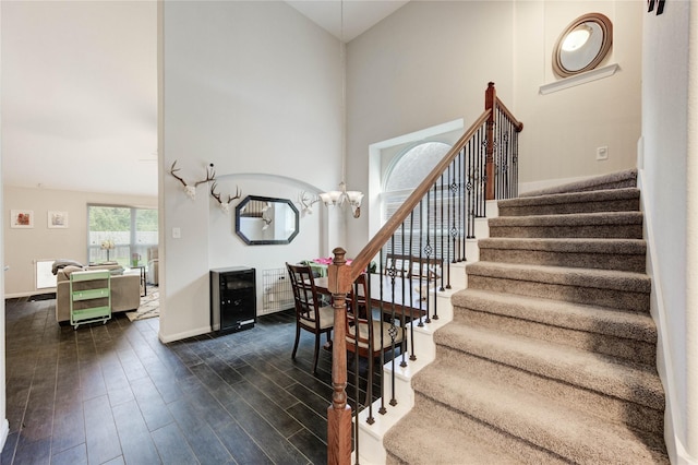 18226 Golden Falls Ln, Spring, TX 77379 - stairway featuring wood finished floors, a towering ceiling, a chandelier, and baseboards