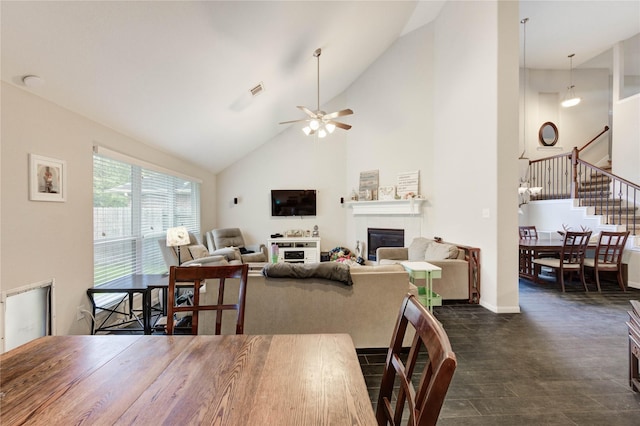 18226 Golden Falls Ln, Spring, TX 77379 - dining area featuring high vaulted ceiling, a tiled fireplace, stairway, ceiling fan, and baseboards