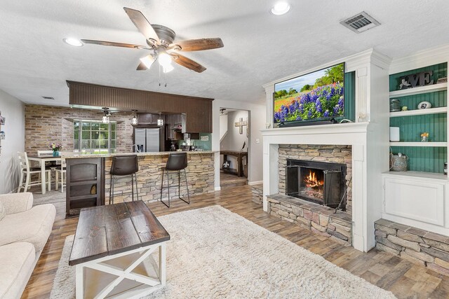 842 Broad Ripple Dr, Houston, TX 77336 - living area with ceiling fan, wood finished floors, a fireplace, and a textured ceiling