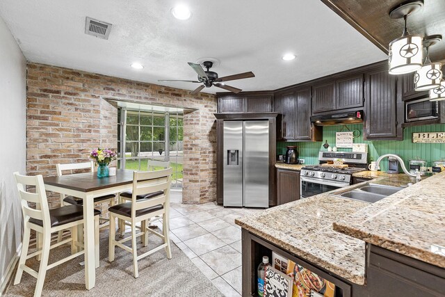 842 Broad Ripple Dr, Houston, TX 77336 - kitchen with appliances with stainless steel finishes, a sink, ceiling fan, under cabinet range hood, and brick wall