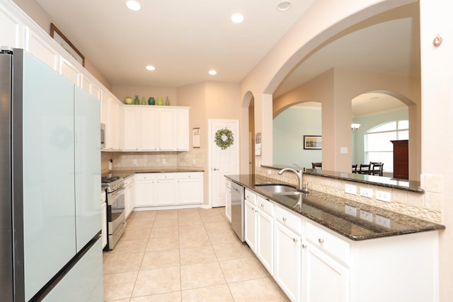18123 Quarry Vale Dr, Cypress, TX 77429 - kitchen featuring appliances with stainless steel finishes, a sink, decorative backsplash, dark stone countertops, and white cabinetry