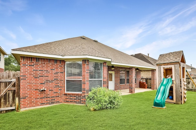 18123 Quarry Vale Dr, Cypress, TX 77429 - back of house with a playground, brick siding, a shingled roof, and a patio