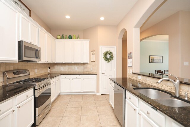 18123 Quarry Vale Dr, Cypress, TX 77429 - kitchen featuring stainless steel appliances, a sink, white cabinetry, tasteful backsplash, and dark stone countertops