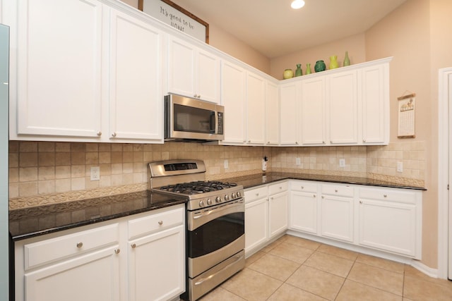18123 Quarry Vale Dr, Cypress, TX 77429 - kitchen featuring appliances with stainless steel finishes, white cabinetry, tasteful backsplash, dark stone countertops, and light tile patterned flooring