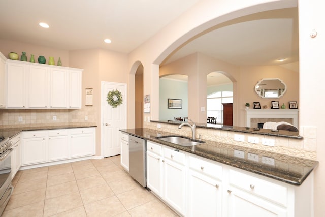 18123 Quarry Vale Dr, Cypress, TX 77429 - kitchen with a sink, stainless steel appliances, decorative backsplash, dark stone countertops, and arched walkways