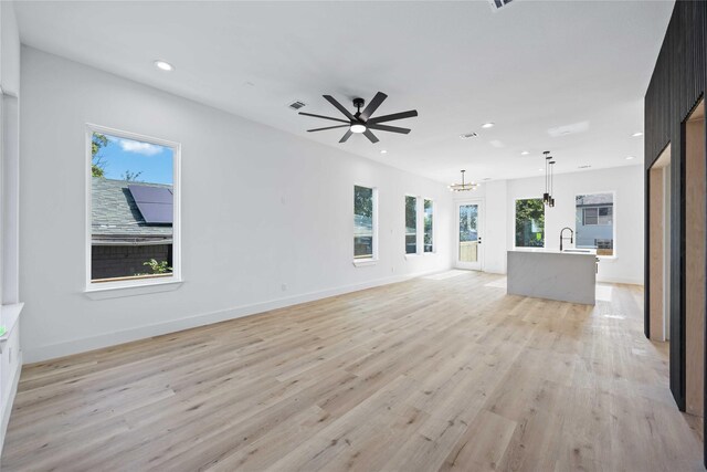 2206 Bleker St, Houston, TX 77026 - unfurnished living room featuring a chandelier, light wood-style floors, recessed lighting, ceiling fan, and a sink