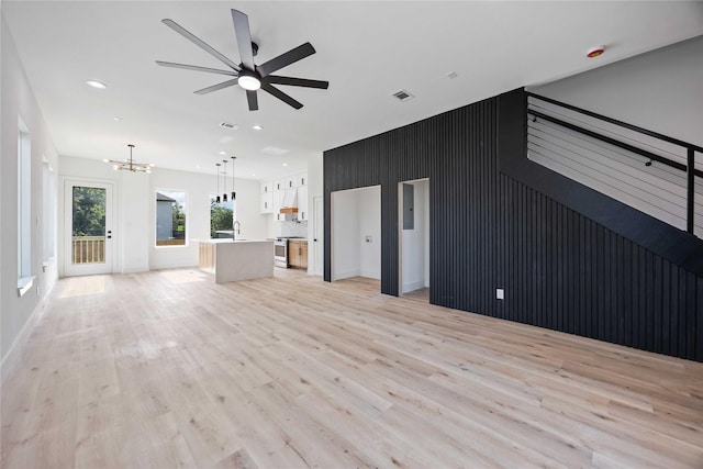 2206 Bleker St, Houston, TX 77026 - unfurnished living room featuring light wood-style floors, a chandelier, a ceiling fan, recessed lighting, and baseboards