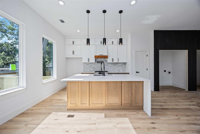 2206 Bleker St, Houston, TX 77026 - kitchen with tasteful backsplash, light countertops, white cabinetry, light wood-type flooring, and recessed lighting