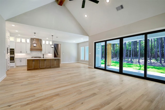 688 Lonestar Rd, Huntsville, TX 77340 - unfurnished living room with high vaulted ceiling, light wood finished floors, ceiling fan, recessed lighting, and beamed ceiling