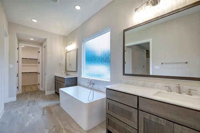 688 Lonestar Rd, Huntsville, TX 77340 - bathroom with marble finish flooring, a freestanding tub, two vanities, recessed lighting, and a walk in closet