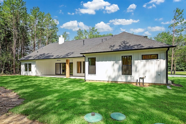 688 Lonestar Rd, Huntsville, TX 77340 - rear view of house with a yard, a chimney, a shingled roof, and a patio