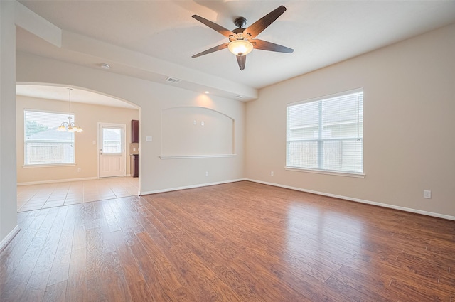 810 Dracena Ct, Richmond, TX 77406 - unfurnished room with a chandelier, wood finished floors, arched walkways, baseboards, and a ceiling fan