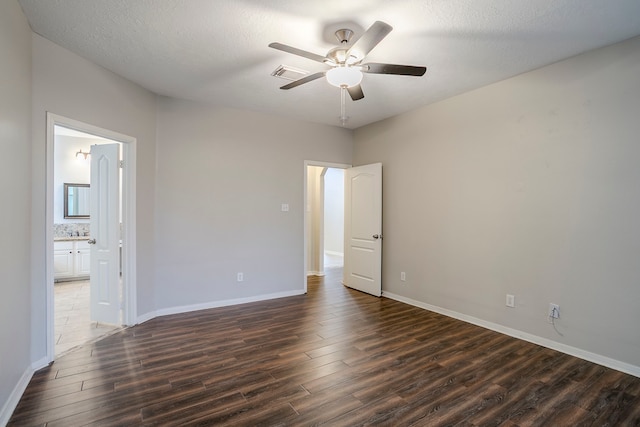 16511 Bluefin St, Crosby, TX 77532 - unfurnished bedroom with dark wood-style flooring, baseboards, connected bathroom, and a ceiling fan