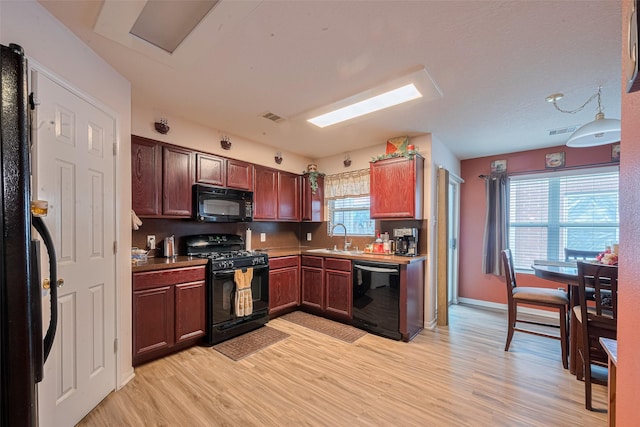 1810 Macondray Dr, Humble, TX 77396 - kitchen featuring black appliances, light wood-type flooring, a sink, and baseboards