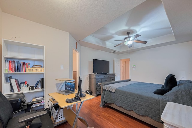 1810 Macondray Dr, Humble, TX 77396 - bedroom featuring a raised ceiling, wood finished floors, a desk, and ceiling fan