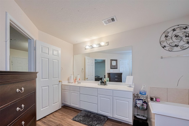1810 Macondray Dr, Humble, TX 77396 - bathroom featuring double vanity, wood finished floors, and a bath