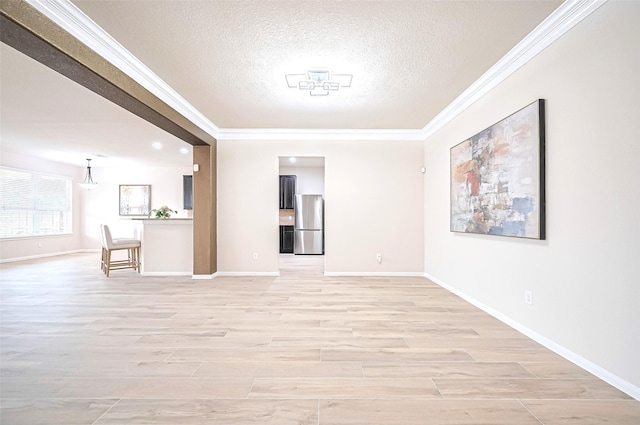 18827 Waverly Springs Ln, Cypress, TX 77429 - spare room with crown molding, a textured ceiling, light wood-type flooring, and baseboards