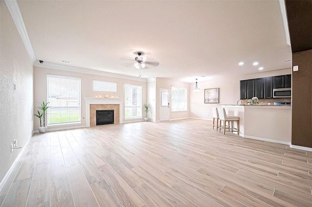18827 Waverly Springs Ln, Cypress, TX 77429 - unfurnished living room featuring crown molding, a ceiling fan, light wood finished floors, baseboards, and recessed lighting